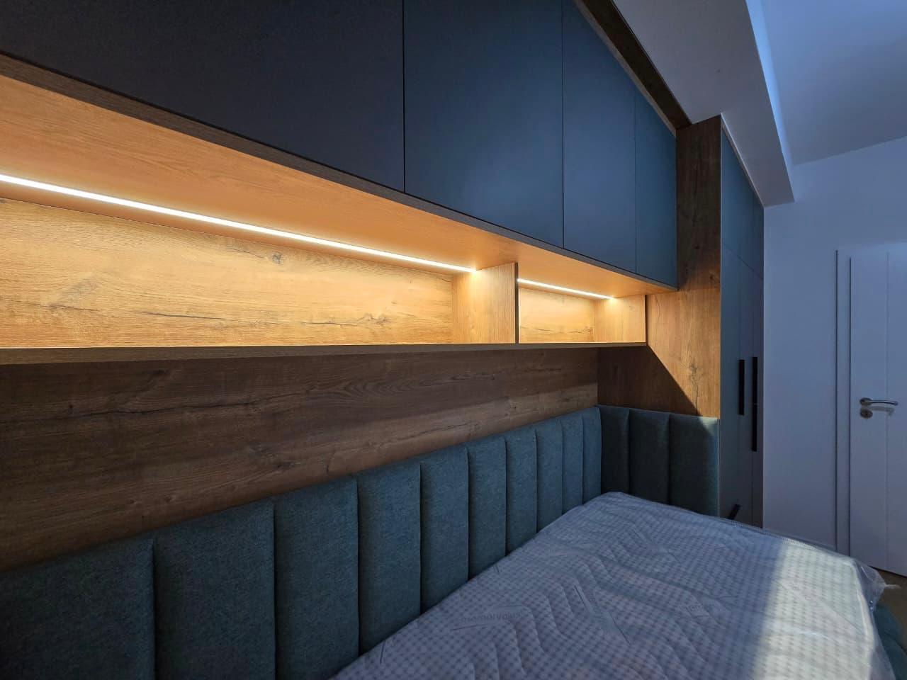Détail tête de lit capitonnée verte et niche bois LED
