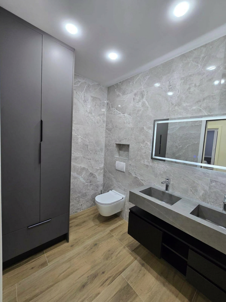 Salle de bain marbre gris avec WC suspendu et double vasque béton